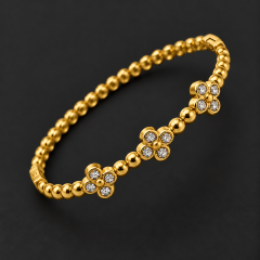 Goldfarbener Armreif mit drei Kleeblatt-Motiven und Strassbesatz